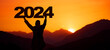 Landscape background banner panorama 2024 - Breathtaking view with black silhouette of mountains and man holding year, in the morning during the sunrise
