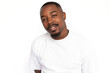 © KAMPUS - Pleased African American man smiling. Portrait of curious young male model with short hair in white T-shirt looking at camera, tilting head with proud look. Success concept
