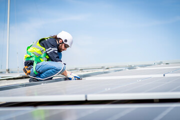 Male engineer installing or checking the working condition of solar panels on the roof or at the height of the factory for saving electricity was broken to use renewable energy from the sun