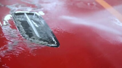 Poster - Rinsing dirt from the paint of a red car with a touchless pressure washer