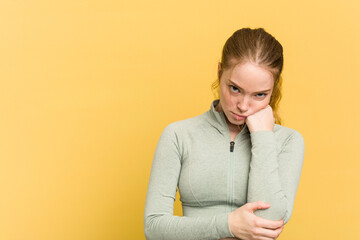 Wall Mural - Young caucasian redhead woman isolated on yellow background who feels sad and pensive, looking at copy space.