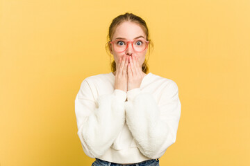 Wall Mural - Young caucasian redhead woman isolated on yellow background shocked covering mouth with hands.