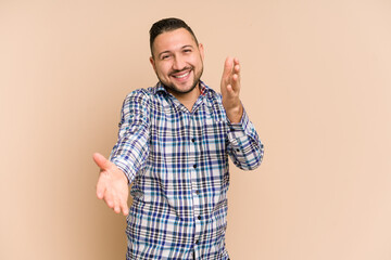 Adult latin man cut out isolated feels confident giving a hug to the camera.