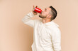 © Asier - Adult latin man drinking cola refreshment isolated