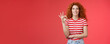 Excellent choice good. Attractive cheerful european redhead curly woman show okay ok approval gesture smiling toothy delighted satisfied awesome perfect service recommend product red background