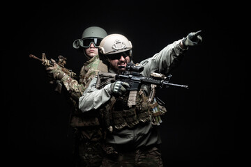 two soldiers in military uniform with weapons in a special operation at night