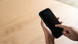 © Thapana_Studio - mockup copy space phone, man's hand holding smartphone with blank white copy screen for your advertising and message or information content, mobile on desk at coffee shop.