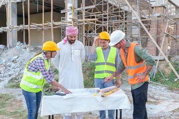 Wall Mural - Diverse team of professionals using tablet computers on construction site. Real estate construction project. with civil engineers, architects, Arabic business investors and explorer with theodolite