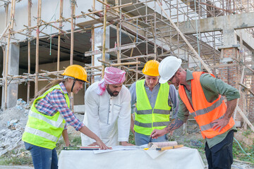 Wall Mural - Diverse team of professionals using tablet computers on construction site. Real estate construction project. with civil engineers, architects, Arabic business investors and explorer with theodolite