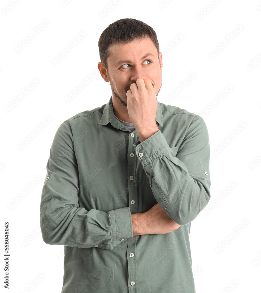Handsome man in shirt biting nails on white background