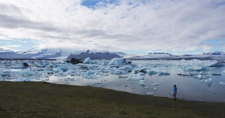 Wall Mural - jokulsarlon glacial lagoon lake in iceland amazing icelandic nature landscape. woman tourist hiker w