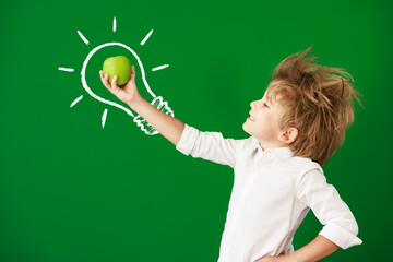 Wall Mural - Surprised child against green chalkboard in class