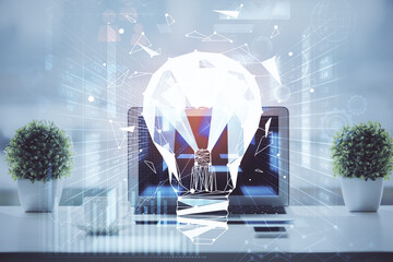 Canvas Print - Computer on desktop in office with bulb icon hologram. Double exposure. Concept of idea.