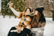 © Roman - Best friends taking selfie in winter