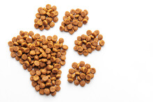 A Dog's Paw Print Consists Of Dog Food Pellets On A White Background.