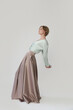 © triocean - Studio shot of female fashion model in beige maxi circle skirt, Simplistic and elegant silk satin full length skirt