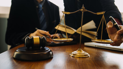 Business and lawyers discussing contract papers with brass scale on desk in office. Law, legal services, advice, justice and law concept picture with film grain effect