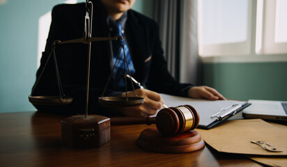 Business and lawyers discussing contract papers with brass scale on desk in office. Law, legal services, advice, justice and law concept picture with film grain effect