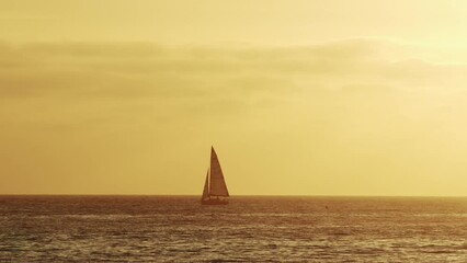 Wall Mural - beautiful evening sunset with a sailing yacht in the atlantic ocean on the coast of portugal.