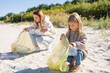 © Julija - Mother and daughter are cleaning up the beach from plastic. save the planet concept.
