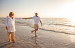 © Darren Baker - Happy Senior Old Retired Couple Walking Holding Hands on Beach at Sunset
