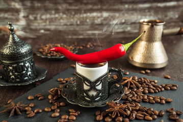 Wall Mural - traditional turkish coffee in vintage cup, anise, roasted beans with hot spicy chili pepper on brown background  3