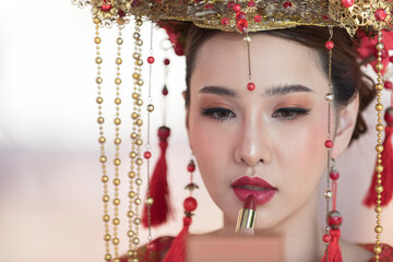 portrait of a woman. person in traditional costume. woman in traditional costume. Beautiful young woman in a bright red dress and a crown of Chinese Queen posing 