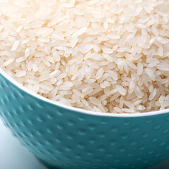 Wall Mural - Bowl full of rice on white background.  Close-up. Copy-space. Ingredient for a healthy diet.