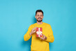 © New Africa - Happy man with gift box on light blue background