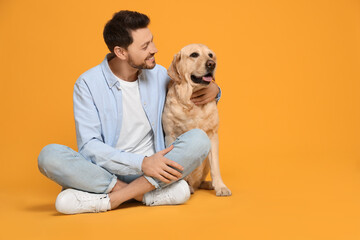 Poster - Happy man with his cute Labrador Retriever on yellow background. Space for text