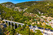 White Arc Bridge, Viaduct of Eze or Devil bridge, over Alpes canyon seen from historic town of Eze rising over Azure Cost of Mediterranean Sea in France