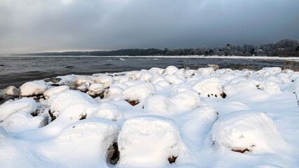 winter landscape from the seashore, lying pieces of ice on the seashore, sand and ice texture in the dunes