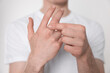 © New Africa - Man suffering from pain in his hand on light background, closeup. Arthritis symptoms