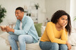 © Prostock-studio - Angry offended millennial african american lady sad at guy with phone, suffer from addiction to games
