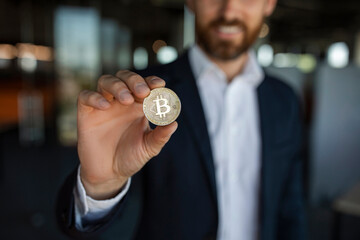 Poster - Digital cryptocurrency, trading on stocks and markets. Unrecognizable middle aged businessman holding golden bitcoin