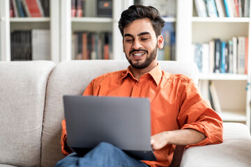 Wall Mural - Cheerful middle eastern man digital nomad working from home