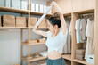 © tai - beautiful woman stretching body using cloth in dressing room. motivated woman stretching exercising holding towel with healthy concept. pretty woman balance body holding cloth relax control breathing