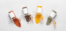 Overturned Jars With Different Spices On Light Background, Top View