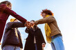 © Xavier Lorenzo - Multiracial group of friends giving fist bump together showing unity outdoors