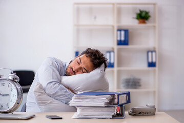 Wall Mural - Young male employee in oversleeping concept