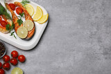 Fototapeta Kawa jest smaczna - Tasty grilled salmon steaks and ingredients on light grey table, flat lay. Space for text