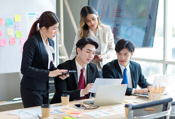 Wall Mural - Millennial Asian young professional successful  businessman in formal suit with female and male businessman colleague in formal suit brainstorming  in company office room.