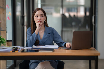 Asian businesswoman looking very bored at her desk.