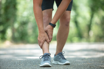 Wall Mural - young fit man holding knee with hands in pain