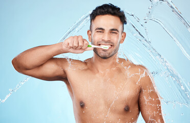 Poster - Face, water splash and man with toothbrush for cleaning in studio on blue background. Dental veneers, hygiene and portrait of happy male model brushing teeth for oral wellness, health or fresh breath