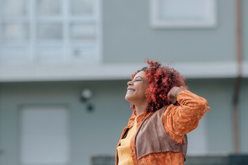 Wall Mural - smiling afro girl in the street outdoors enjoying relaxed