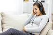 © Andrii - Photo of side view of pregnant woman with headphones.