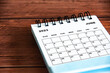 © Maurice Yom - June 2023 white desk calendar on wooden table background. Calendar concept and copy space