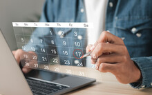 Businessman Manages Time For Effective Work. Calendar On The Virtual Screen Interface. Highlight Appointment Reminders And Meeting Agenda On The Calendar. Time Management Concept.