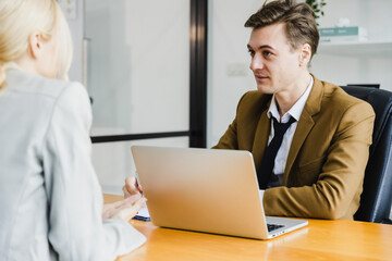 Wall Mural - Two colleagues are concentrating and thinking, a man and a woman in business clothes are discussing business strategy